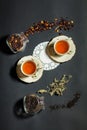 Two cups of tea on the black background with disperse tea