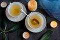 Two cups of tea on black table and candles