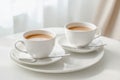 Two cups of tea with saucers and spoons on a white tray in a bright, cozy setting Royalty Free Stock Photo