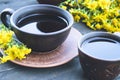 Two cups of tea stand on wooden old boards with yellow chamomile flowers Royalty Free Stock Photo