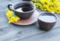 Two cups of tea stand on wooden old boards with yellow chamomile flowers Royalty Free Stock Photo