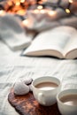 Two cups of coffee, open book and cookies on the bed. Cozy morning at home while reading and having breakfast in bed. Hygge Royalty Free Stock Photo