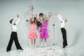 two curly-haired girls and two boys engaged in ballroom dancing, laughing and mischievously posing in a photo studio