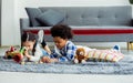 Two cute adorable Caucasian little girl and African black boy playing toys together with happiness on floor in living room at Royalty Free Stock Photo