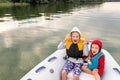 Two cute adorable little caucasian sibling boy and girl wearing lifejacket vest having fun enjoy riding inflatable Royalty Free Stock Photo