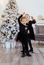 Two cute adorable little sisters near christmas tree in cozy living room. Royalty Free Stock Photo