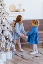 Two cute adorable little sisters near christmas tree in cozy living room. Royalty Free Stock Photo