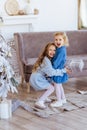 Two cute adorable little sisters near christmas tree in cozy living room. Royalty Free Stock Photo