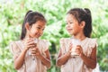 Two cute asian child girls drinking a milk from glass together Royalty Free Stock Photo