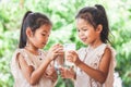 Two cute asian child girls drinking a milk from glass together Royalty Free Stock Photo