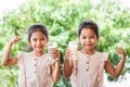 Two cute asian child girls drinking a milk from glass together Royalty Free Stock Photo