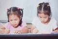 Two cute asian child girls having fun to draw and paint together Royalty Free Stock Photo