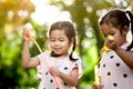 Two cute asian child girls having fun to play with bubbles Royalty Free Stock Photo