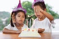 Two asian child girls lighting candle on birthday cake together in birthday party Royalty Free Stock Photo
