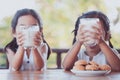 Two cute asian little child girls holding glass of milk Royalty Free Stock Photo