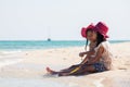 Two asian little child girls sitting and playing with sand together on the beach near the beautiful sea in summer vacation Royalty Free Stock Photo