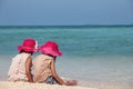 Two cute asian little child girls sitting and playing with sand together on the beach near the beautiful sea Royalty Free Stock Photo