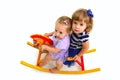 Two cute babies riding on a toy horse Royalty Free Stock Photo