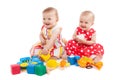 Two cute baby girls playing with toys, isolated on white. Having fun, smiling