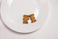 Cute bears cookies on the ceramic round plate on white background. View from above, flat lay