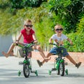 Two cute boys riding on bicycles, legs raised Royalty Free Stock Photo