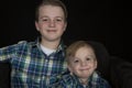 Two cute brothers portrait wearing matching shirts smiling at ca