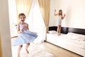 Two cute carefree little sisters girls in casual clothes playing having fun in childrens room Royalty Free Stock Photo