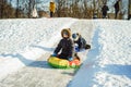 Cute caucasian boy with a big snow spade on playground in kindergartentwo cute caucasian boys sledding down the icy slope in park Royalty Free Stock Photo