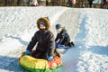 Cute caucasian boy with a big snow spade on playground in kindergartentwo cute caucasian boys sledding down the icy slope in park Royalty Free Stock Photo