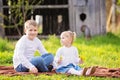 Two cute caucasian small kids, boy and girl, sitting in a grass Royalty Free Stock Photo