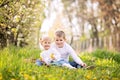 Two cute caucasian small kids, boy and girl, sitting in a grass Royalty Free Stock Photo
