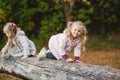 Two cute children climb, balance on a fallen log in an park Royalty Free Stock Photo