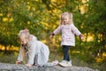 Two cute children climb, balance on a fallen log in an park Royalty Free Stock Photo