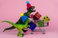 cute dinosaurs in knitted hats with shopping trolley full of present boxes, sale concept