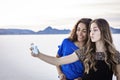 Two cute and diverse teenage girls posing and taking a selfie together outdoors Royalty Free Stock Photo