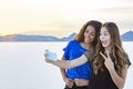 Two cute and diverse teenage girls posing and taking a selfie together outdoors Royalty Free Stock Photo