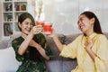 Two cute female friends drank from a glass of sweet red wine with a sweet delicacy in the living room at home. Royalty Free Stock Photo