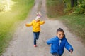 Two cute funny preschool Caucasian children boy girl running playing in park outside on autumn fall day.