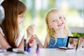 Two cute funny sisters applying make-up on sunny summer day at home Royalty Free Stock Photo