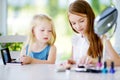 Two cute funny sisters applying make-up on sunny summer day at home Royalty Free Stock Photo