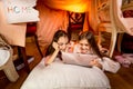 Two cute girls using digital tablet in bedroom at night Royalty Free Stock Photo