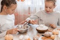 Two cute girls whip gingerbread dough to make halloween cookies in home kitchen. Treats and preparations for the halloween Royalty Free Stock Photo