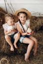 Cute girls in hay hats keeping little chickens in village Royalty Free Stock Photo