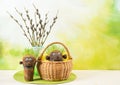 Two cute homemade grass heads with furry willow tree branches with catkins in vase.