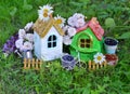 Two cute houses with summer berry, watering can and flowers in the garden Royalty Free Stock Photo