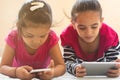 Two cute Indian children busy in watching Mobile phone on bed.