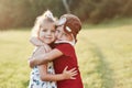 Two cute kids hugging each other outside, near the beautiful woods.