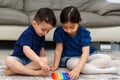 Two cute kids playing with flexible toy the Pop It fidget. Royalty Free Stock Photo