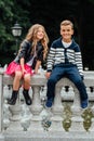 Two cute kids are sitting on the railing. Marble-stone fountain. Royalty Free Stock Photo