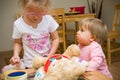 Two little girls playing together at home with plush toys Royalty Free Stock Photo